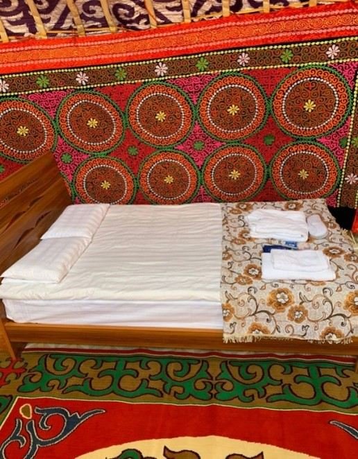 A made bed with fresh linen inside a ger