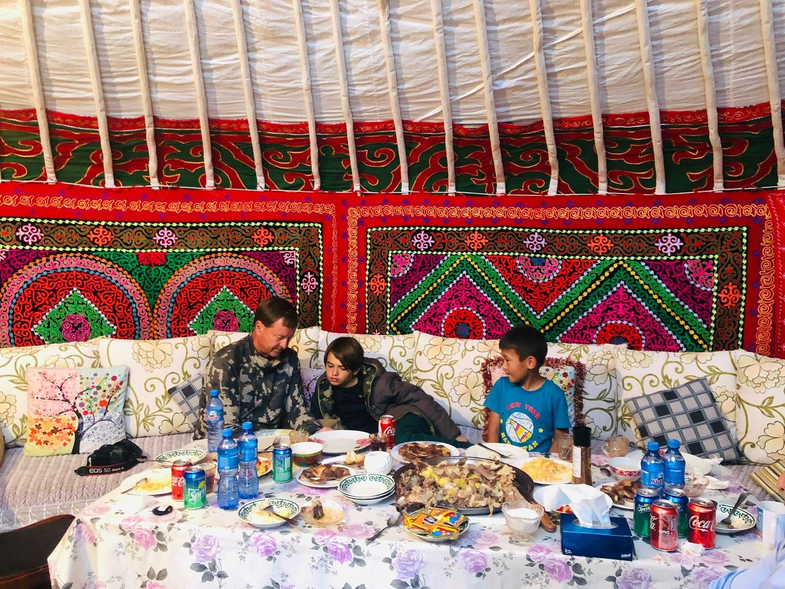 Guests sharing a meal inside a decorated ger